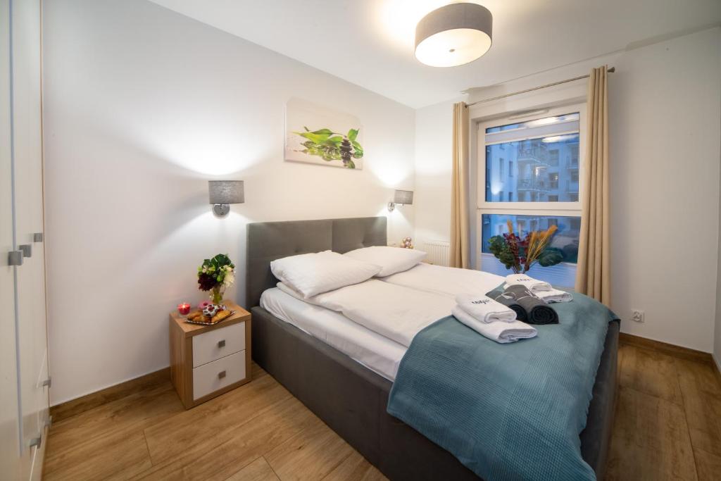 Schlafzimmer mit einem Bett und einem Fenster in der Unterkunft Maya's Flats & Resorts 43 -Swietej Babary in Danzig