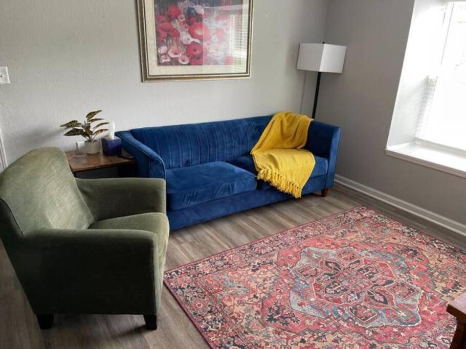 sala de estar con sofá azul y silla en The Bernice - 2 Bedroom Apt in Quilt Town, USA, en Hamilton