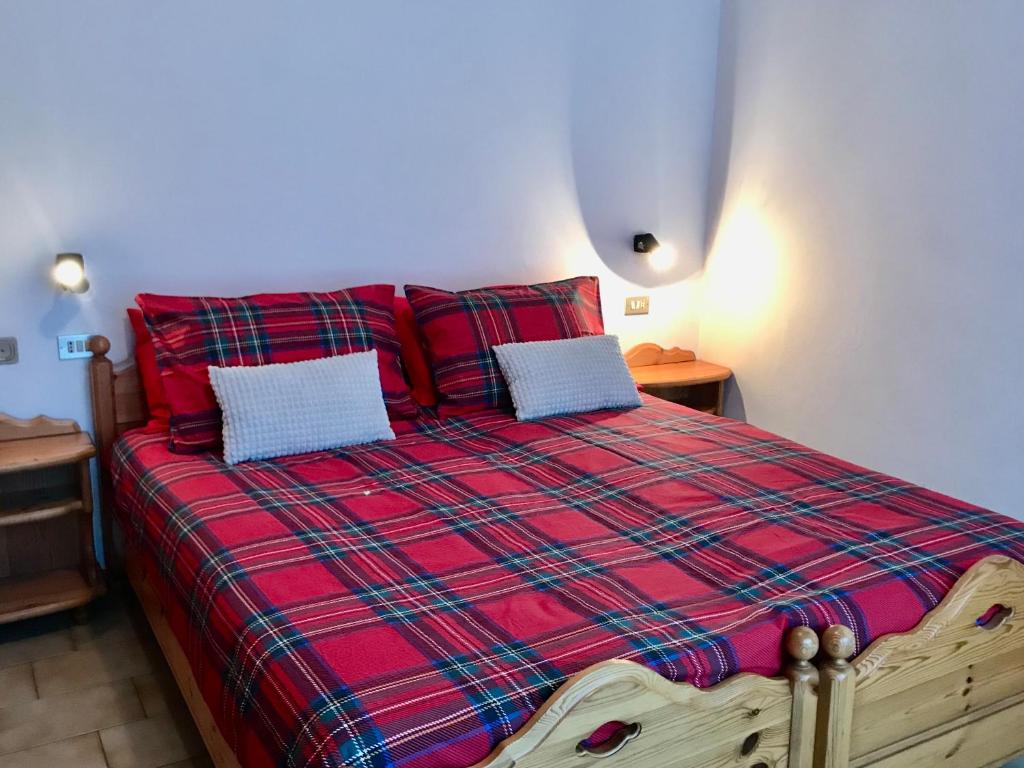 een slaapkamer met een rood bed met 2 kussens bij Chalet Bormino 4 in Bormio