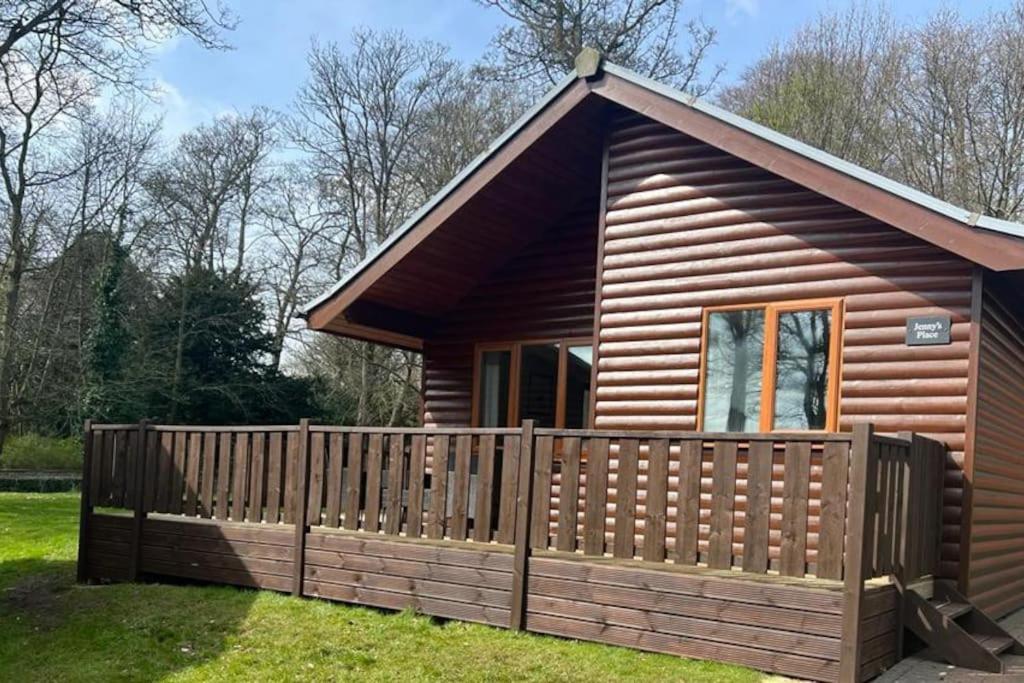 a small log cabin with a wooden fence at Jenny's Place Stunning 2 bedroom lodge in Sewerby
