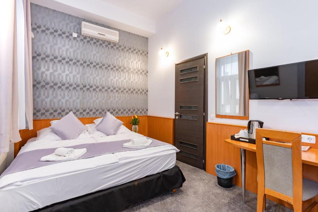 Habitación de hotel con cama y escritorio en Budapest Griffin Guest House, en Budapest