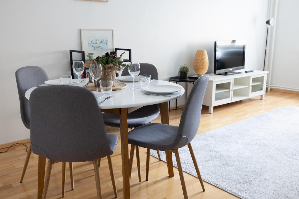 een eetkamer met een witte tafel en stoelen bij 2ndhomes Charming Central 1BR City Apartment with Great Location in Helsinki