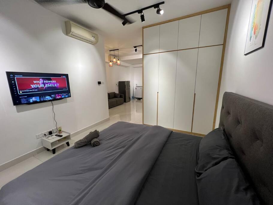 1 dormitorio con 1 cama y TV en la pared en Teega Suites #2203 Puteri Harbour Iskandar Puteri en Nusajaya