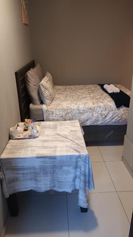a room with two beds and a table with bowls on it at Budget self-contained room in Pretoria