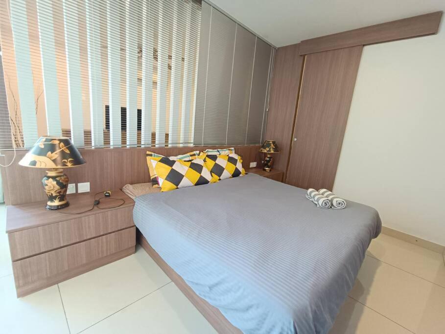 Dormitorio pequeño con cama y lámpara en KSL City Mall Bathtub 1-4pax Netflix JB City en Johor Bahru