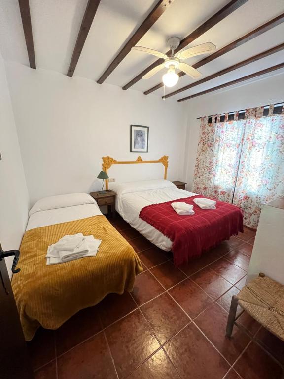 a bedroom with two beds and a ceiling fan at Casa Jara in Jimera de Líbar