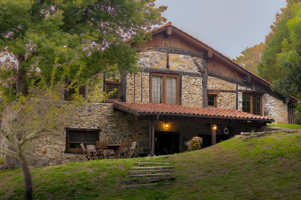 una casa de piedra con una mesa delante en Relax, montaña, paz, en Régil