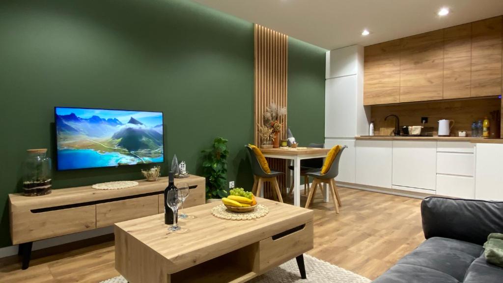 ein Wohnzimmer mit einem Sofa, einem TV und einem Tisch in der Unterkunft Apartament Park in Przemyśl