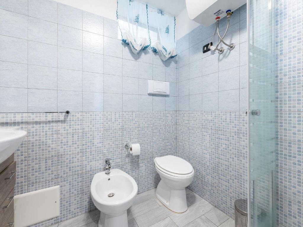 a bathroom with a toilet and a glass shower at VILLA CLAUDIO e LUNETTA in Villasimius