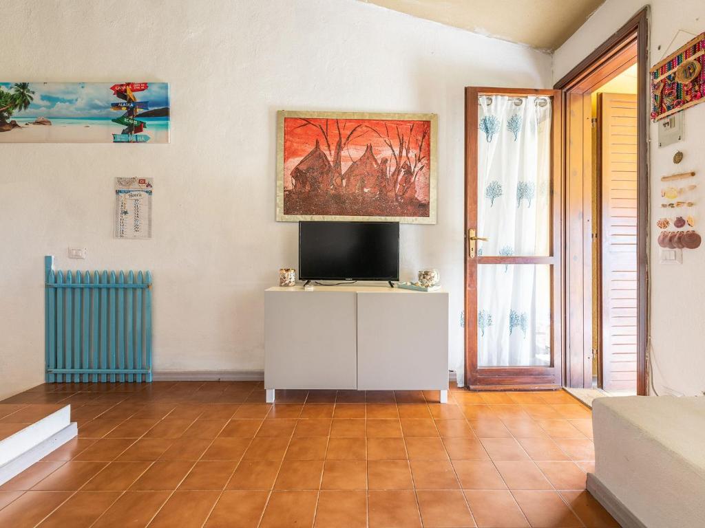 a living room with a tv on a white cabinet at VILLA CLAUDIO e LUNETTA in Villasimius