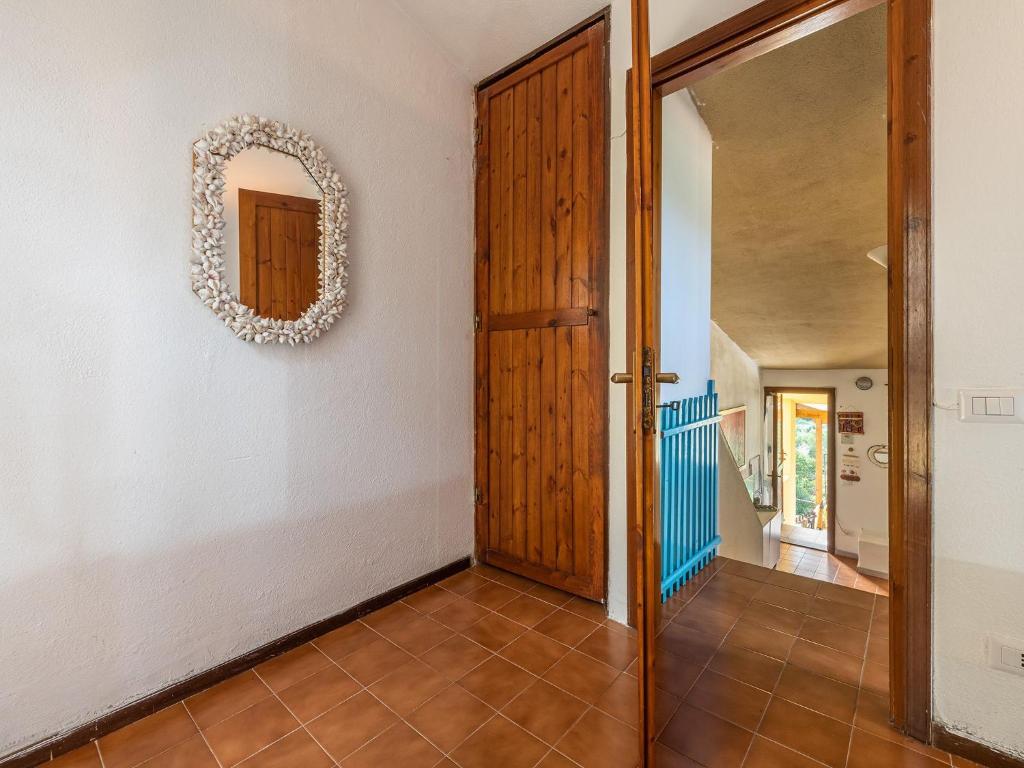 a hallway with a door and a mirror on the wall at VILLA CLAUDIO e LUNETTA in Villasimius