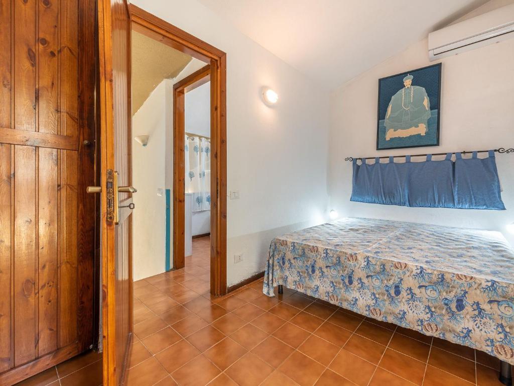 a small bedroom with a bed and a mirror at VILLA CLAUDIO e LUNETTA in Villasimius