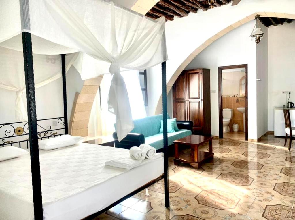 Rizokarpaso的住宿－Karpaz Lembusa Guest House，一间卧室设有一张床和一间客厅。