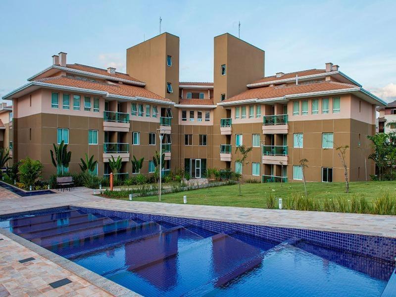 a swimming pool in front of some apartment buildings at The Sun Flat Beira Lago in Brasília