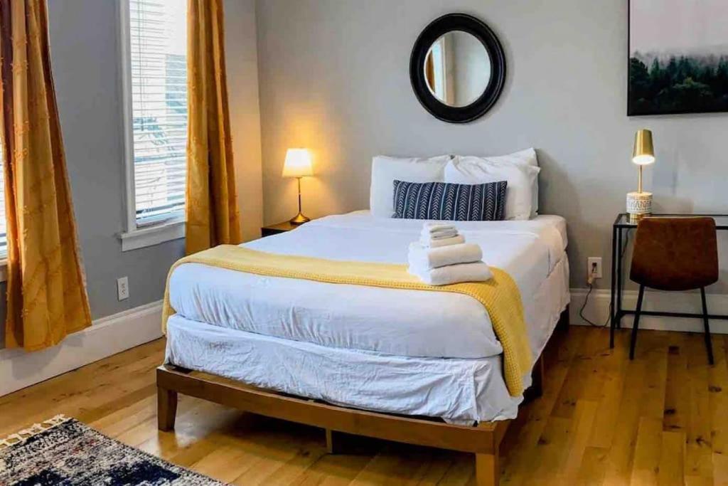 a bedroom with a large bed with a mirror on the wall at HostWise Stays - The Ohioan - Beautiful Brick Apt, Minutes to Downtown! in Pittsburgh