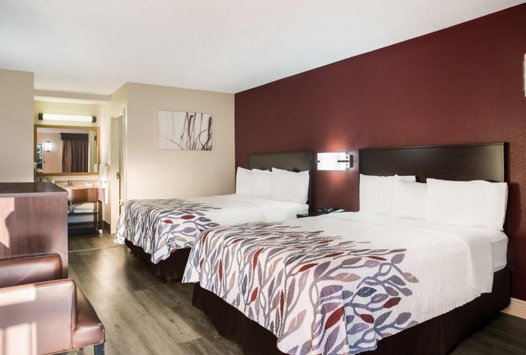 una camera d'albergo con due letti e un bagno di Red Roof Inn Tupelo a Tupelo