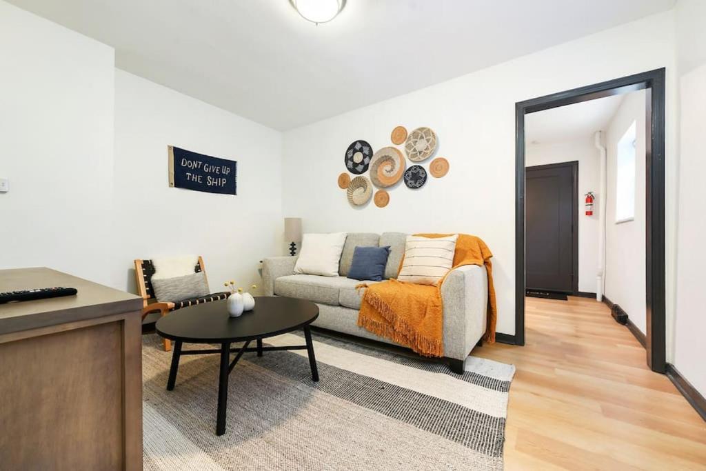 ein Wohnzimmer mit einem Sofa und einem Tisch in der Unterkunft HostWise Stays - Pet Friendly Butler St Apt, Ground Floor with Private Entrance in Pittsburgh