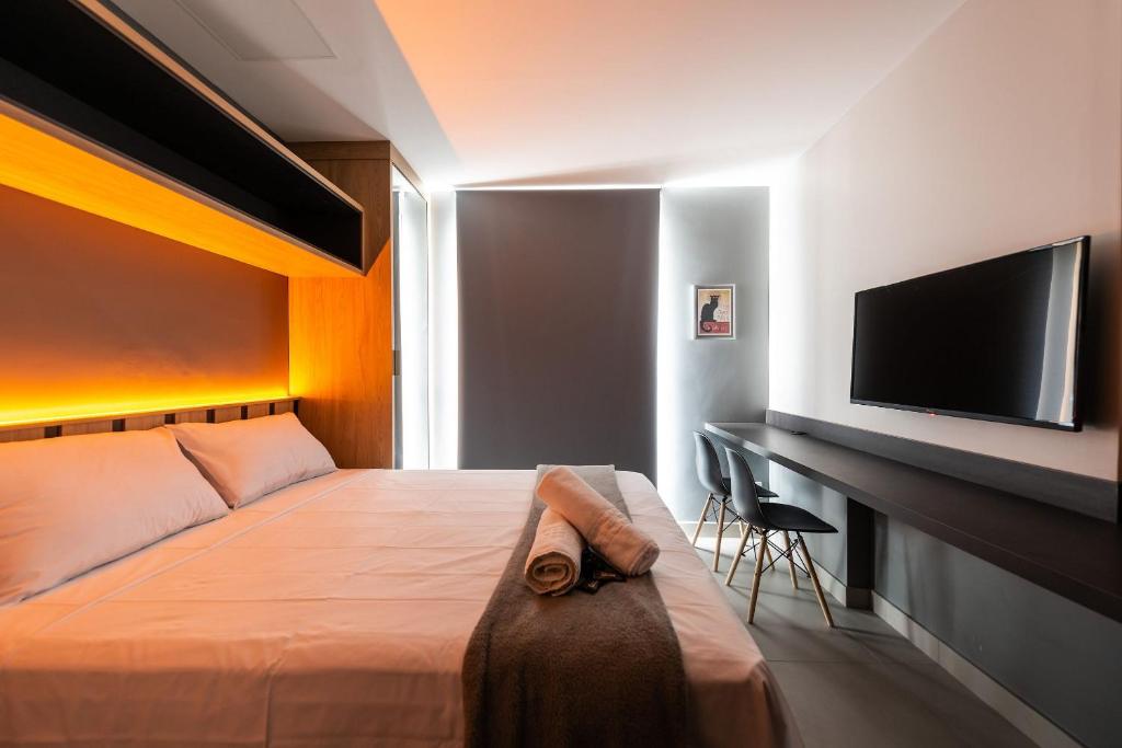 1 dormitorio con 1 cama y escritorio con TV en HO3 - Studio na Vila Mariana: Moderno e Completo., en São Paulo
