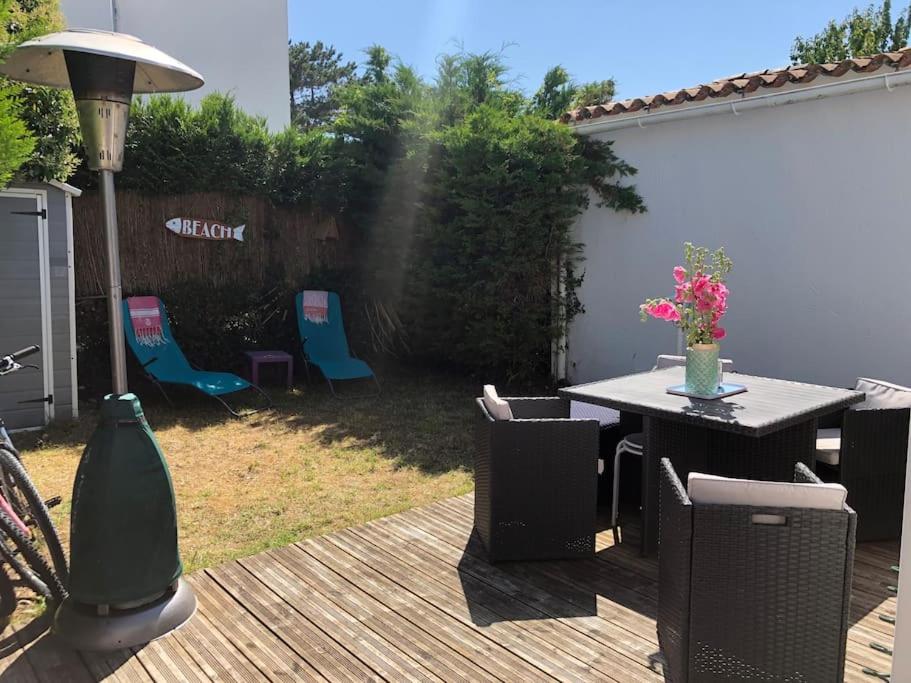 patio ze stołem i krzesłami na tarasie w obiekcie Agréable maison, plage à 400m, jardin, piscine et tennis w mieście Saint-Palais-sur-Mer