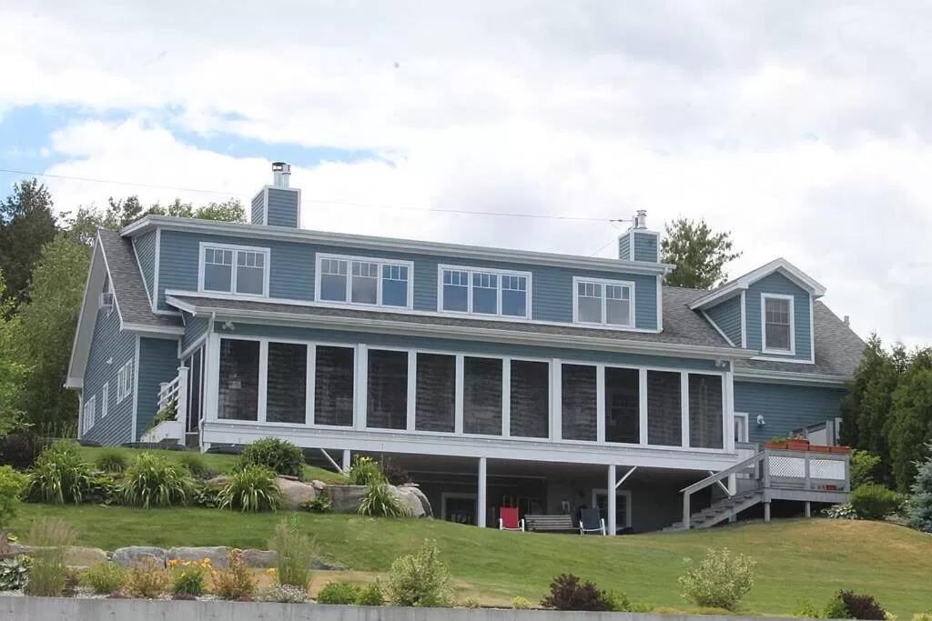 a large blue house with a large porch at Smooth Sailing on Lake Champlain in NY! in Plattsburgh