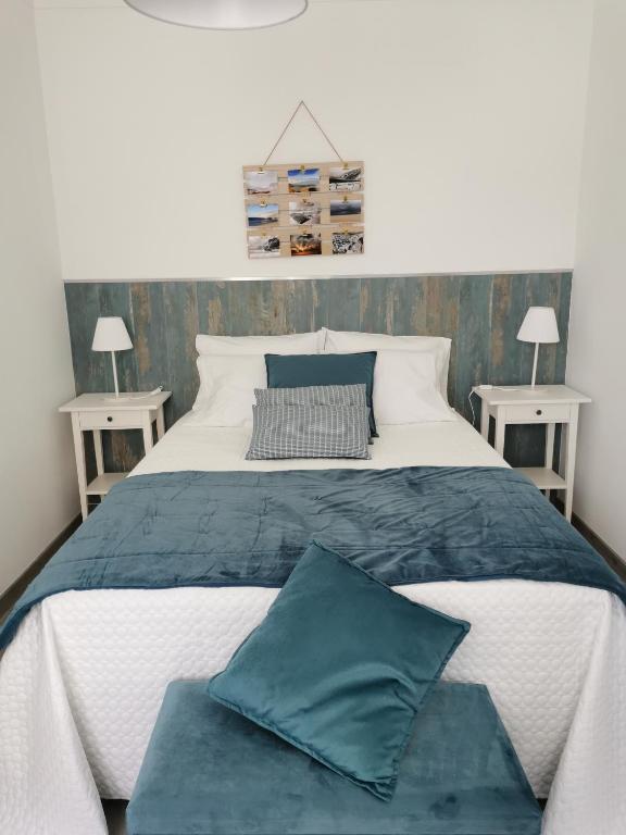 a bedroom with a large bed with two tables at Casas dos Avós in Nazaré