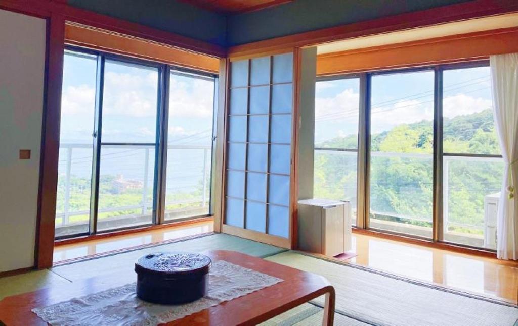 a living room with large windows and a table at Izu One Club - Vacation STAY 10406v in Futo