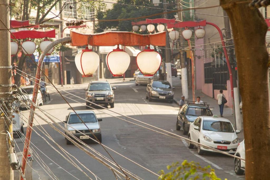 una concurrida calle de la ciudad con coches aparcados en la carretera en Casa na Liberdade by OBA, en São Paulo