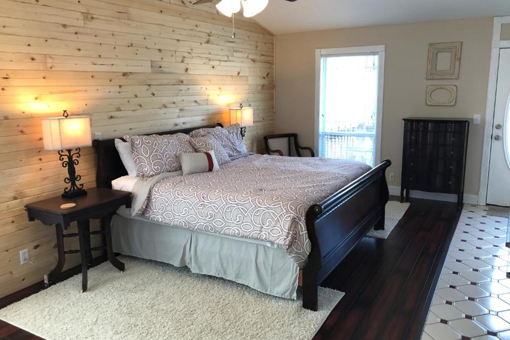 a bedroom with a bed and a wooden wall at Ozark Spring Cabins - Mountain View 01 in Eureka Springs