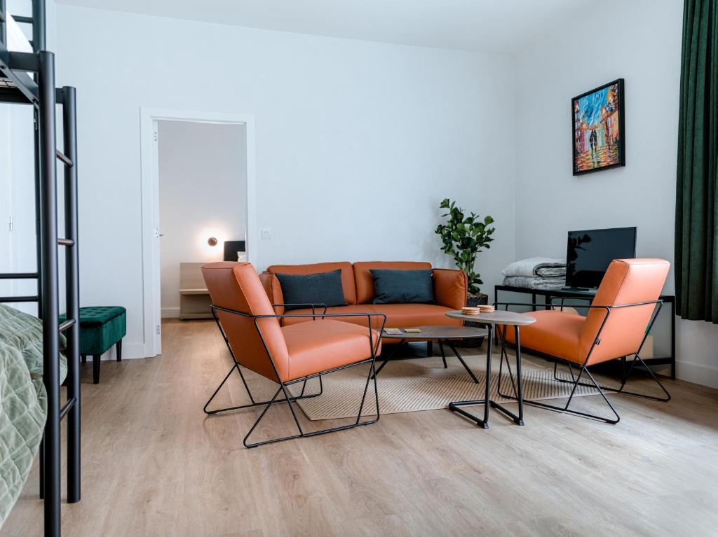 a living room with orange chairs and a couch at Apartment The City in Ghent