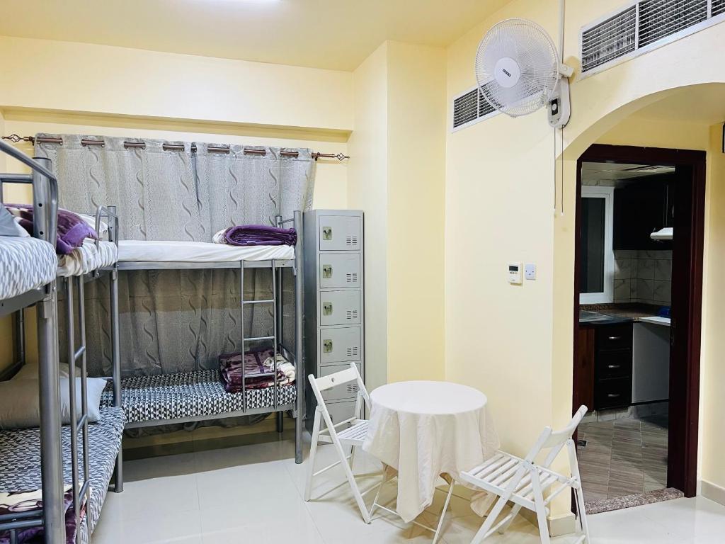 a room with bunk beds and a table and chairs at Comfort Tourist Place for male in Dubai