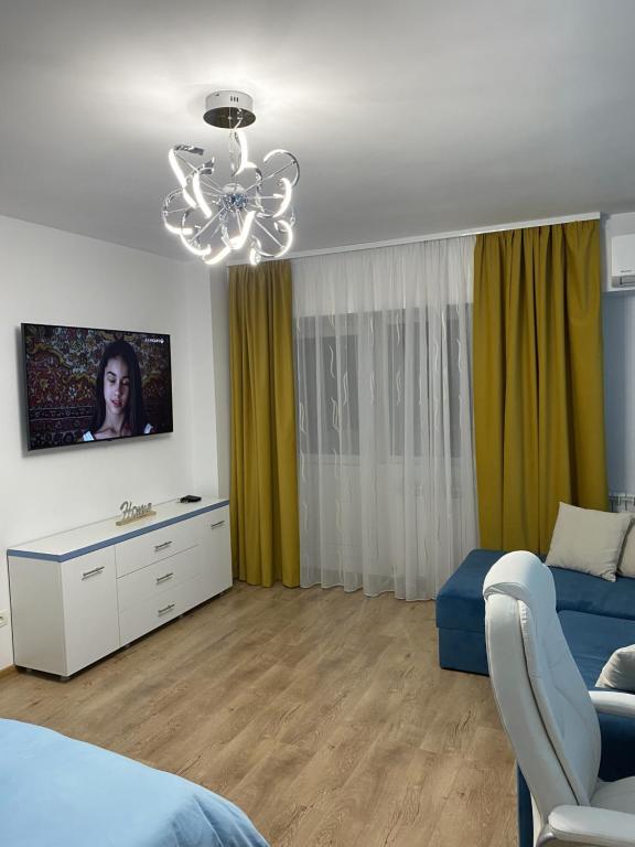 ein Wohnzimmer mit einem Bett und einem Kronleuchter in der Unterkunft Turquoise Studio Nerva Traian in Bukarest