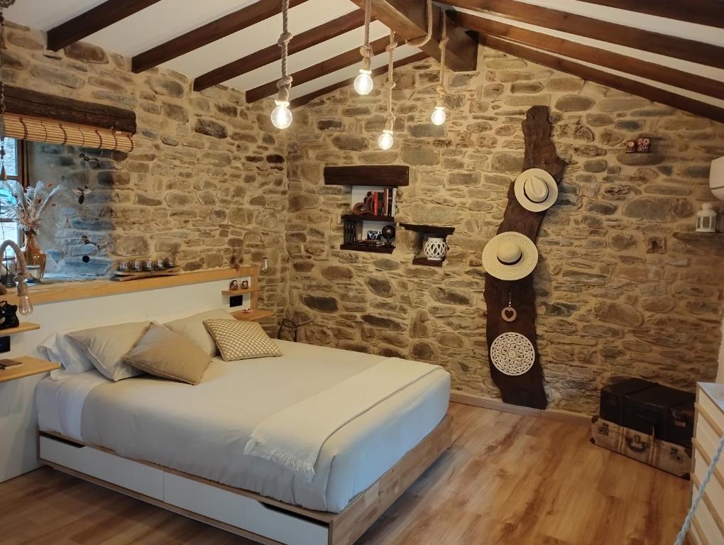 um quarto com uma cama e uma parede de pedra em A curuxa casa rural 