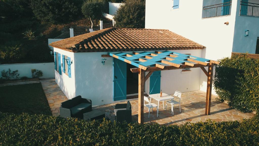 a gazebo with a table and chairs in front of a house at Luciana in La Croix-Valmer