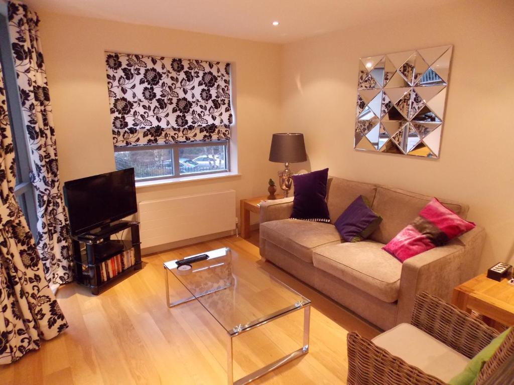 a living room with a couch and a tv at Violet Bank Apartment New Town in Edinburgh