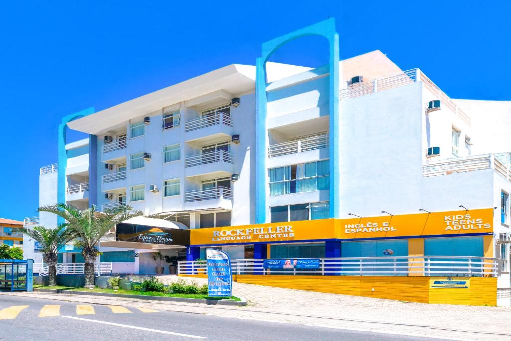 um edifício de apartamentos com uma fachada amarela e azul em Express Floripa Residence em Florianópolis
