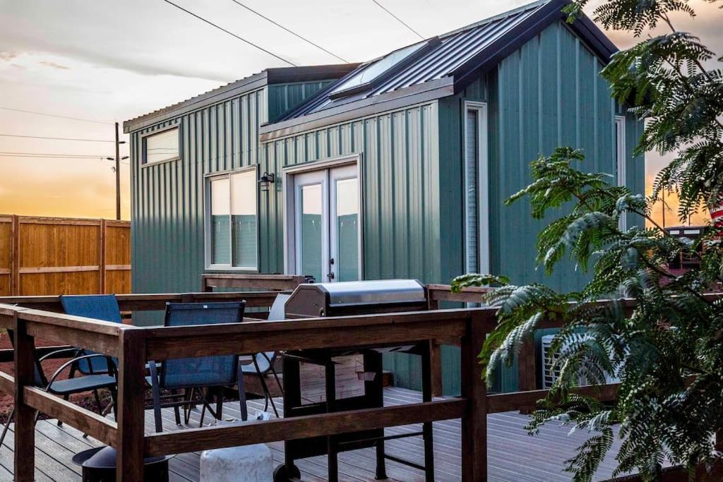 a green house on a deck with a wooden fence at Moonrise Tiny Home in Apple Valley