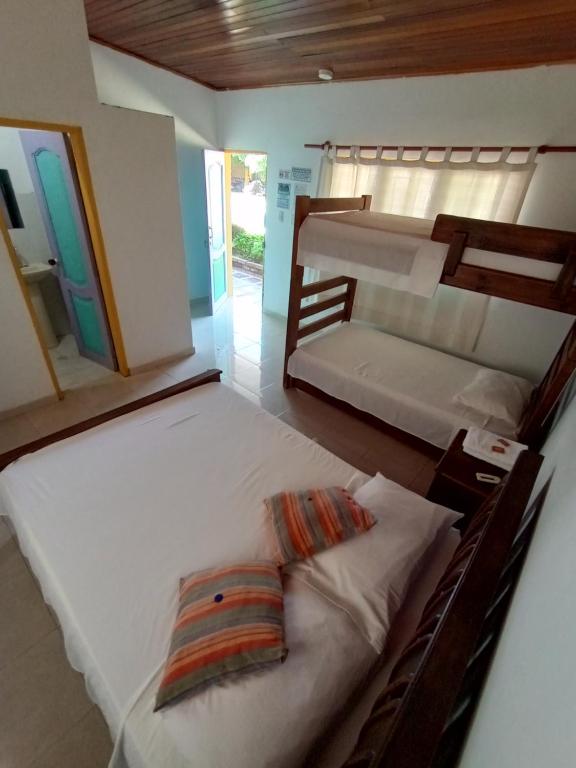 2 camas individuales en una habitación con espejo en Hotel Brisas De Neguanje, en Santa Marta