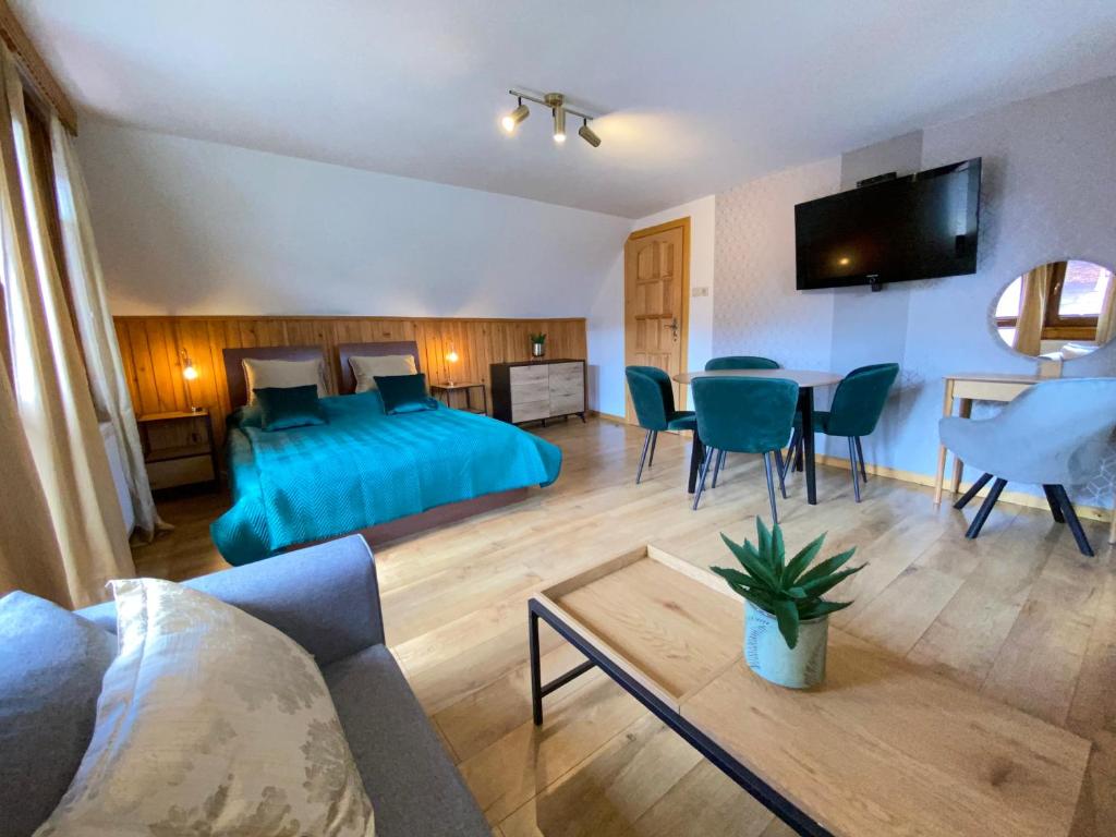 een slaapkamer met een bed, een tafel en stoelen bij Domek Pod Lisem Szczawnica in Szczawnica