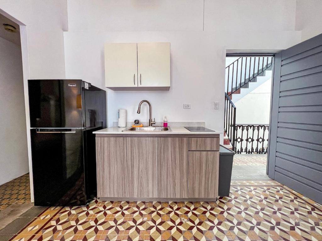 a kitchen with a sink and a refrigerator at Nando's Place in San Juan