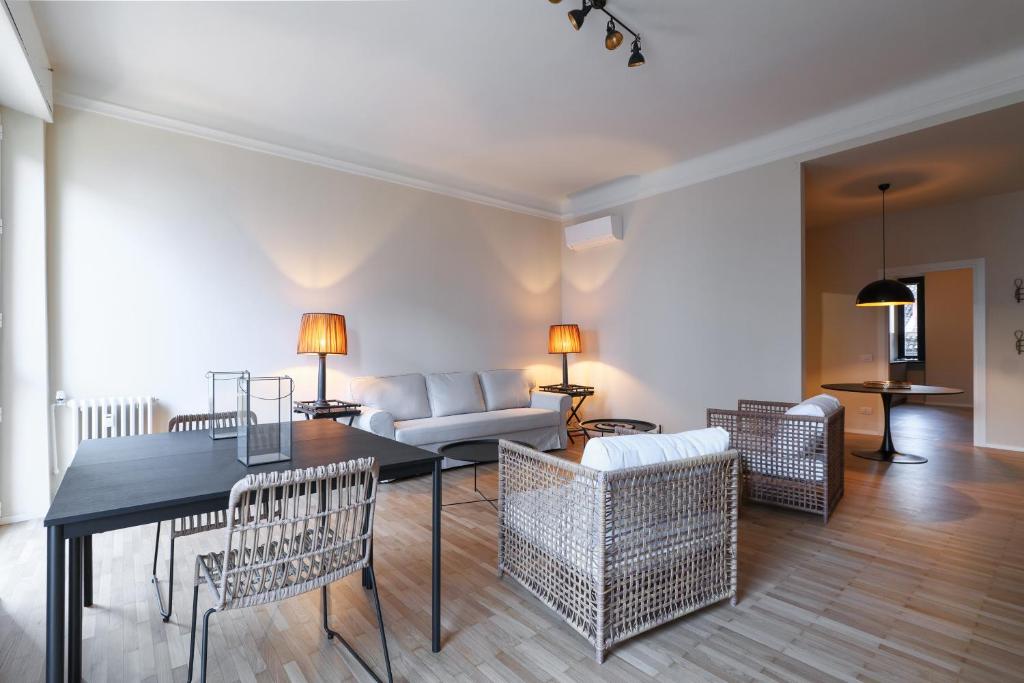 sala de estar con mesa, sillas y sofá en Luxury San Babila Apartment, en Milán