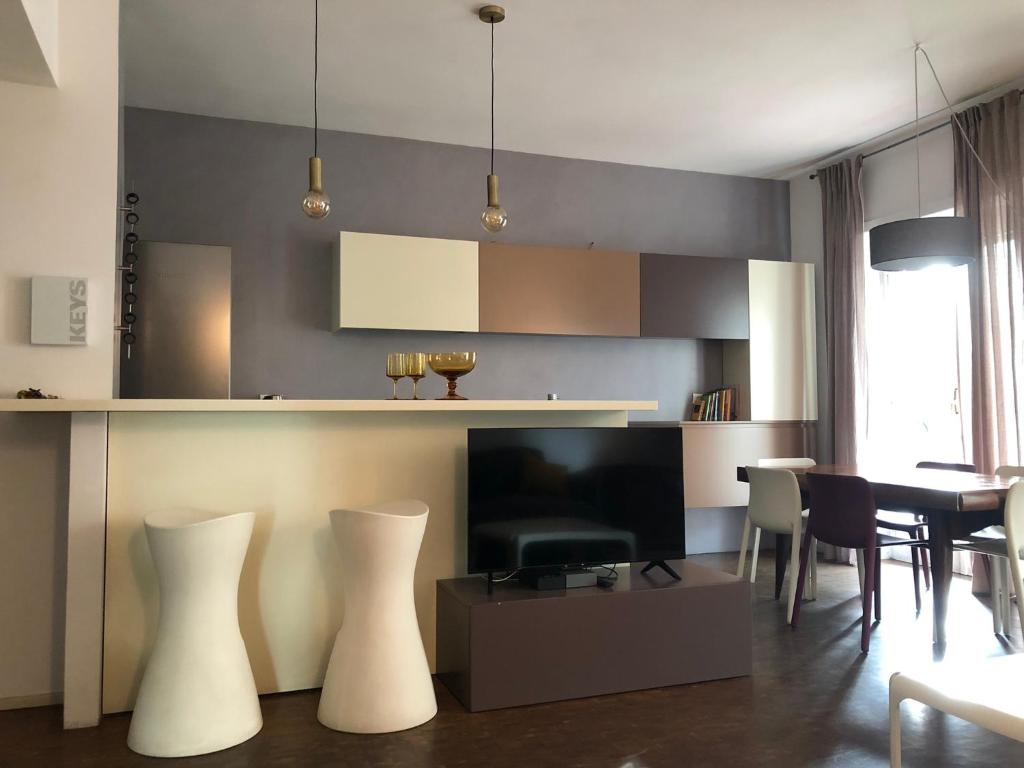 a kitchen and dining room with white chairs and a table at Lungotevere Bed&Bike in Rome