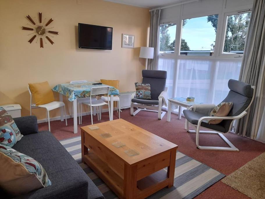 a living room with a couch and chairs and a table at 'Sunnyside' Chalet, walk to the beach & close to Norfolk broads - pet friendly! in Great Yarmouth