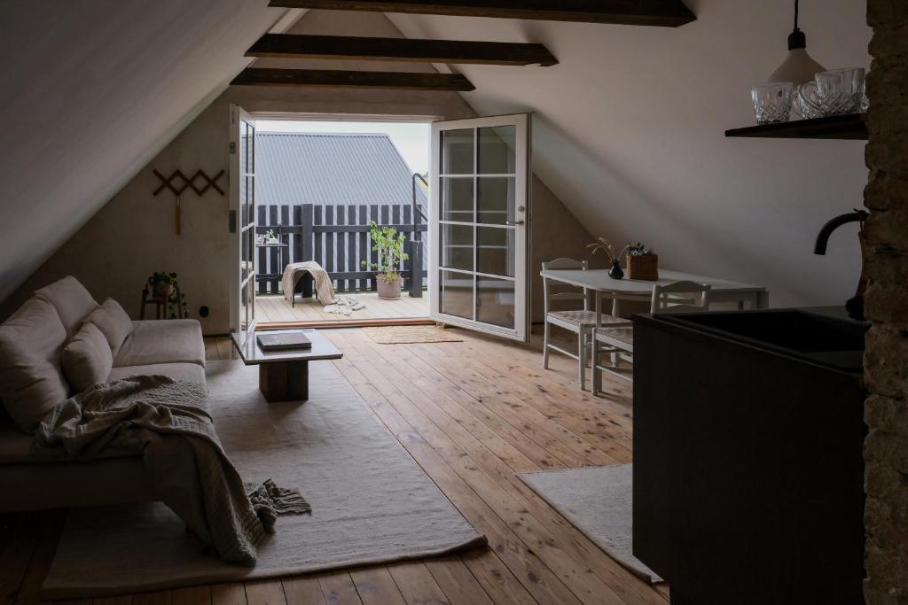 Österlen loft في توميليلا: غرفة معيشة مع أريكة وباب مفتوح
