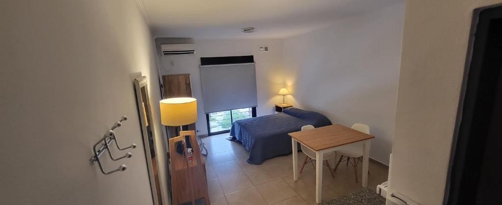 um pequeno quarto com uma cama e uma mesa em Monoambiente Plaza San Miguel em Paraná