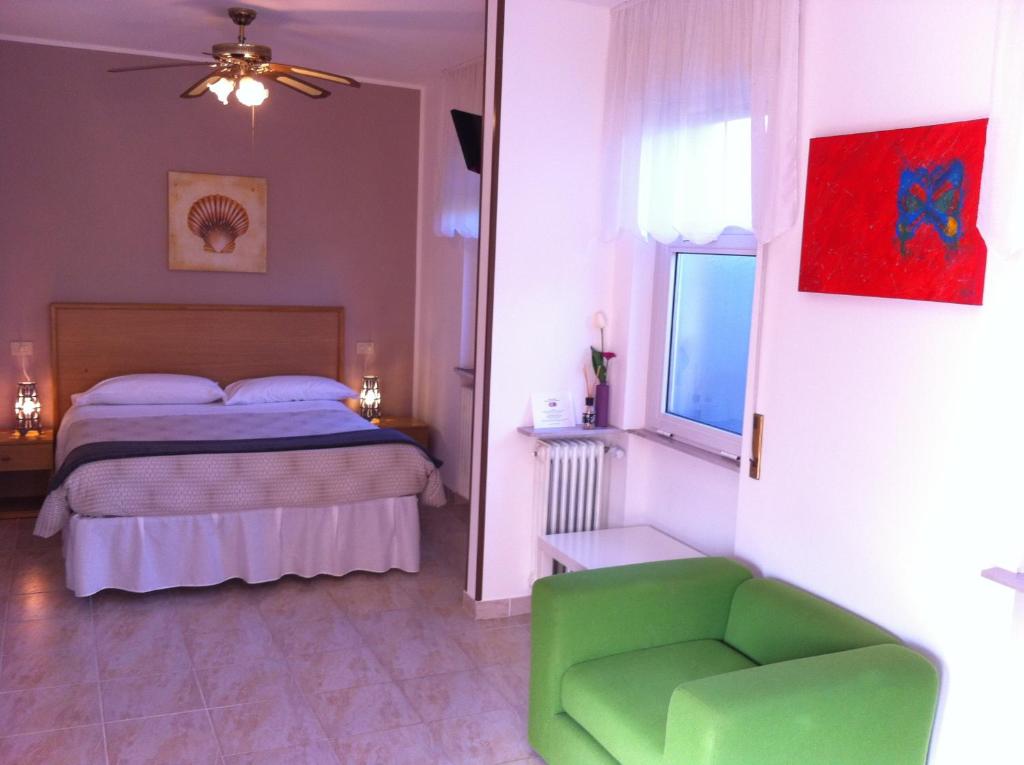 TavagnaccoにあるHotel Modernoのベッドルーム1室(ベッド1台、緑の椅子付)
