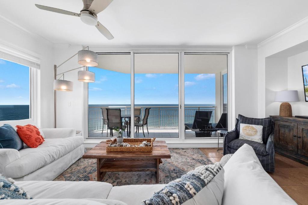 uma sala de estar com mobiliário branco e vista para o oceano em Indigo West 1101 em Perdido Key