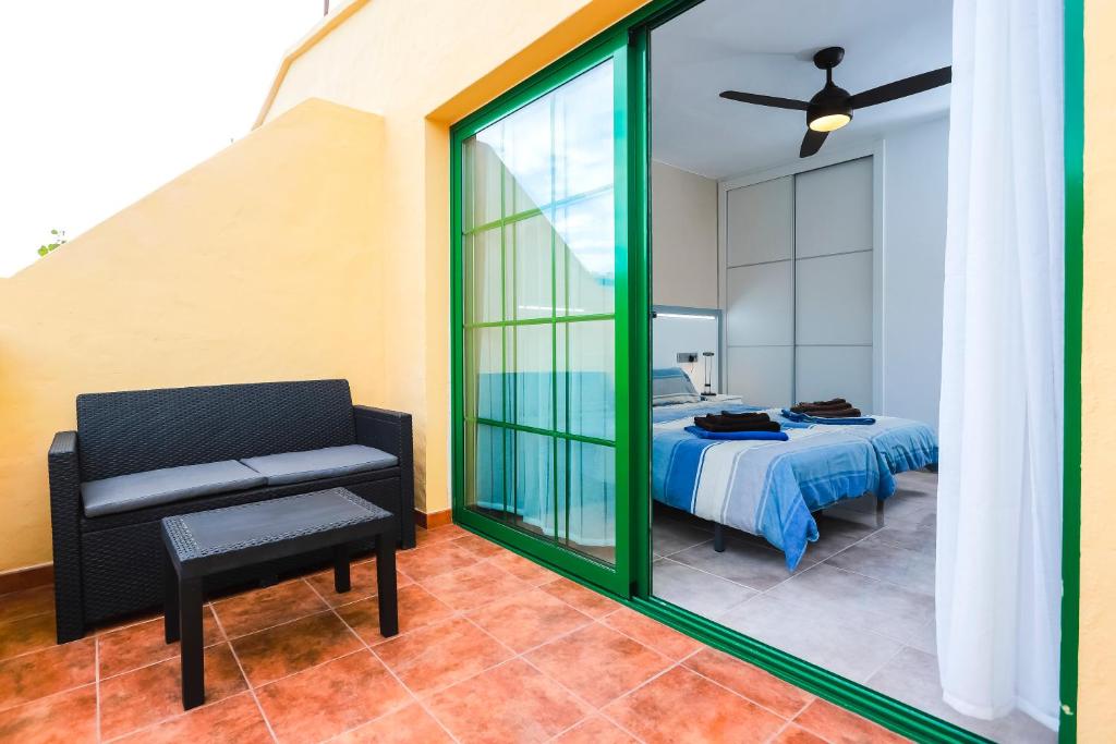 1 dormitorio con 1 cama, 1 silla y 1 ventana en Premium Duplex Castillo Mar 60, en Caleta de Fuste