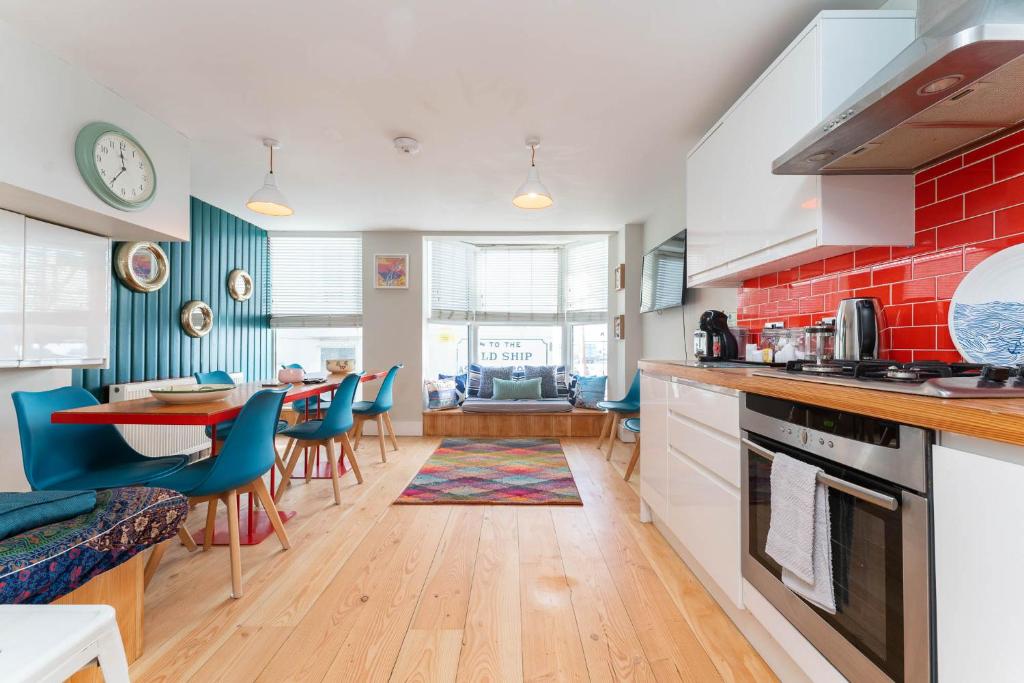 a kitchen and dining room with a red brick wall at Sealanes 2 in Brighton & Hove