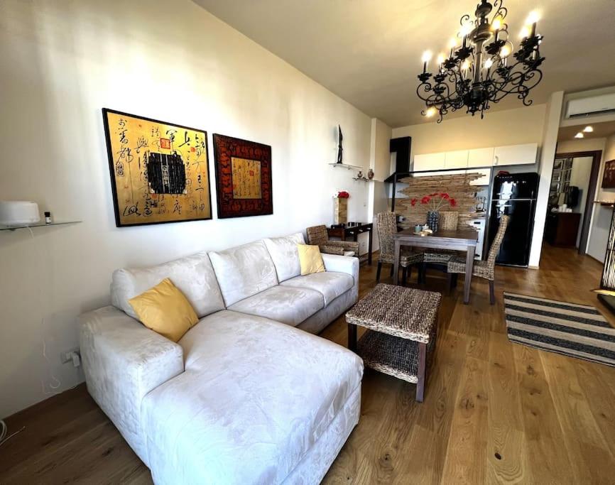 een woonkamer met een witte bank en een tafel bij Poggio delle Ginestre home in Torre Pelosa