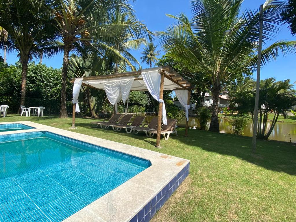 a swimming pool in a yard with a gazebo at Alma Tropical Resort in Vera Cruz de Itaparica